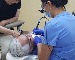 Dr. Wang treating patient in dental chair