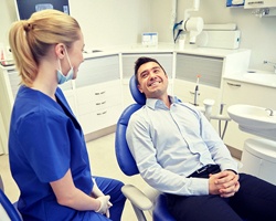 man in blue shirt sitting in dental chair