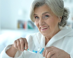 Older woman preparing to brush her teeth