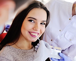 Woman smiling at dentist during veneers consultation
