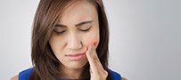 Woman holding jaw in pain