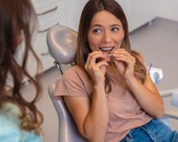 Patient putting on clear aligner