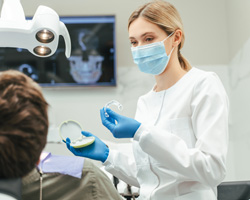 Dentist showing patient clear aligner in treatment room