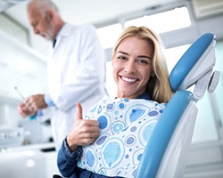 woman giving thumbs up in dental chair