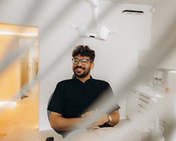 Patient with black glasses smiling in treatment chair