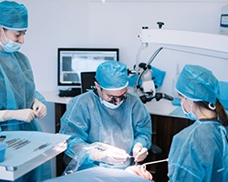 Team carefully performing dental implant surgery