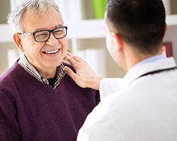 dentist putting his hand on a patient’s shoulder 