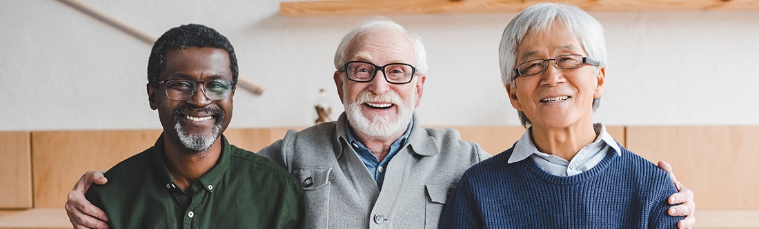 Three older men smiling together