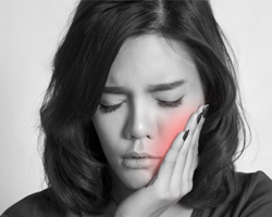Black and white photo of woman with mouth pain