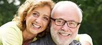 Older man and woman smiling outdoors