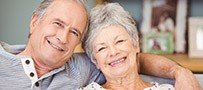 Smiling senior man and woman on couch