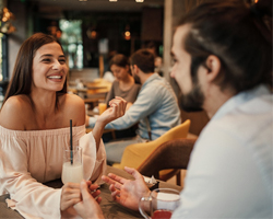 Woman smiling while talking to date during dinner