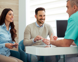  Dentist talking to couple about the cost of a smile makeover in Rolling Meadows