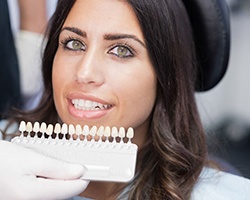 woman in dental chair smiling with veneers