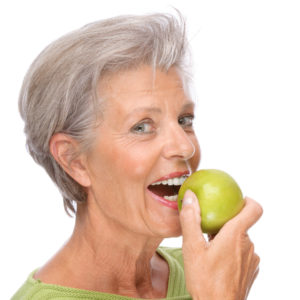 older woman holding green apple