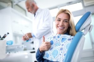 woman giving thumbs up in dental chair