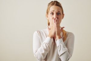 worried woman with covered mouth 