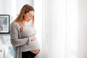 Pregnant woman holding her belly.