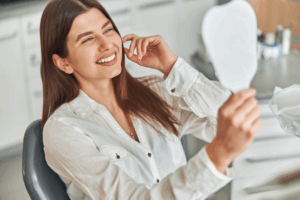 a patient admiring her smile in a mirror
