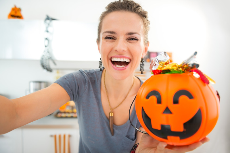 Patient smiling with Halloween candy and no dental emergencies