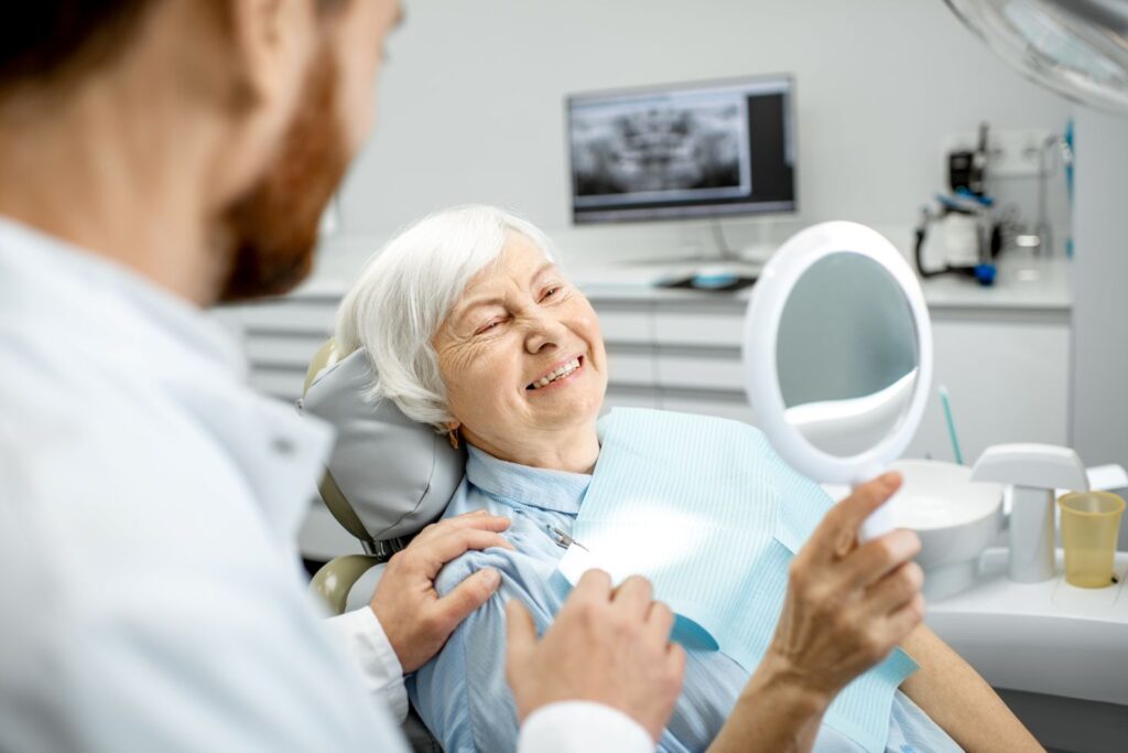 A woman looking in the mirror at her dental implants
